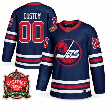 Front and back of navy Winnipeg Jets CUSTOM 00 Heritage Classic 2019 jersey with one enlarged Regina Saskatchewan shoulder patch; physical neck and round hem labels retained with sportswear manufacturer marks removed.